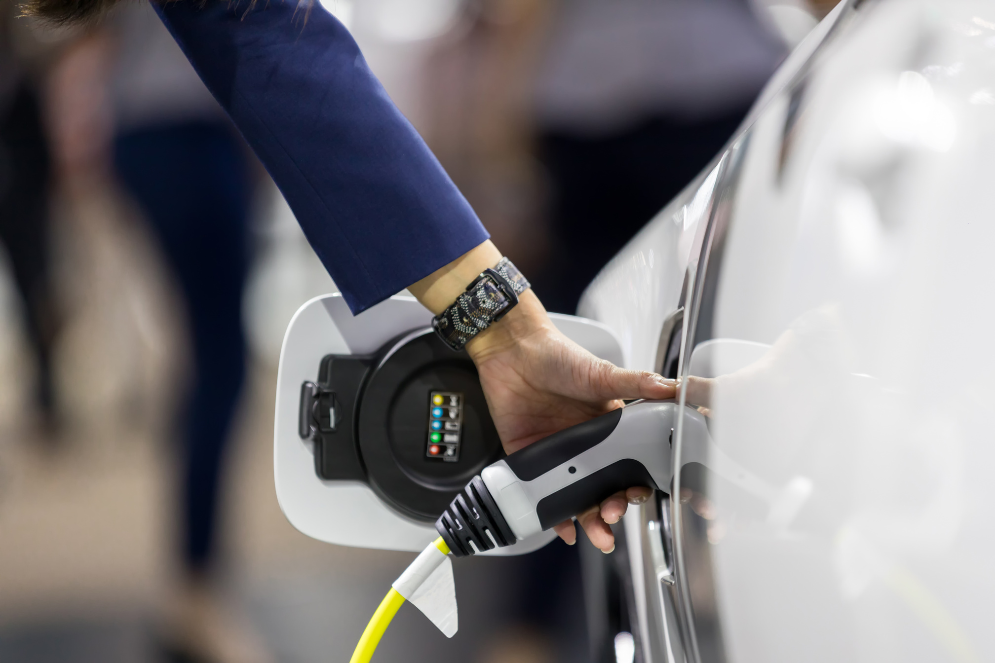 Hand holding Electric car charger. Electric Vehicle EV Charging station and Charger. Human hand is holding Electric Car Charging connect to Electric car.